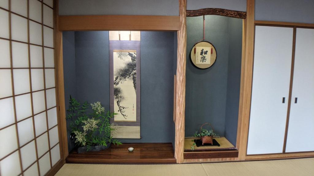 um quarto com um espelho e um relógio na parede em roundabout TOYONAKA em Toyonaka