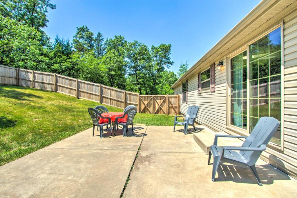 a patio with chairs and a table and a fence at Sunny Wisconsin Dells Apartment with Deck and Fire Pit in Wisconsin Dells