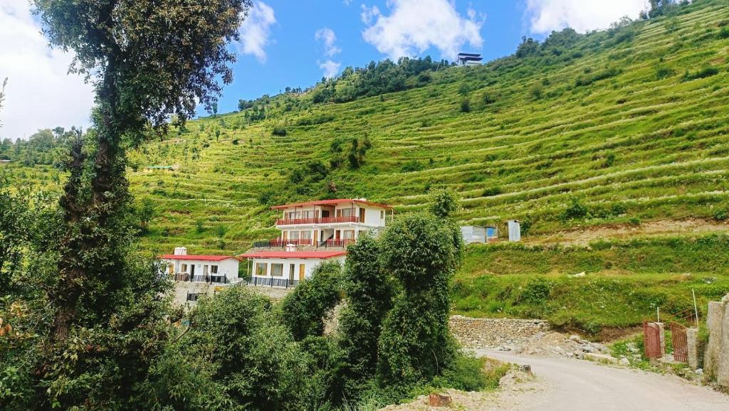 ein Haus an der Seite eines Hügels in der Unterkunft The Vintage Hill Village - Himalayan Boutique Resort in Kanatal