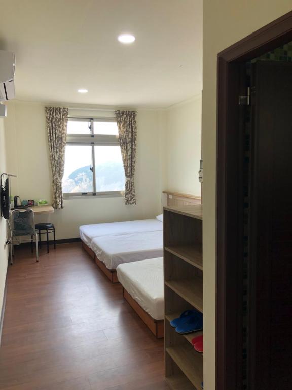 um quarto com uma cama, uma janela e uma secretária em Home run Homestay em Dongyin/