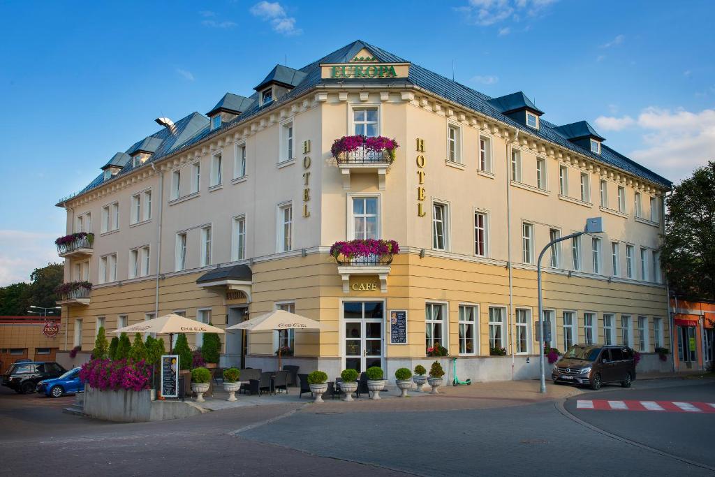 un gran edificio amarillo con flores delante en Hotel Europa en Poprad