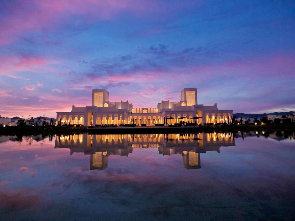 un gran edificio con luces reflectantes en un cuerpo de agua en Banyan Tree Tamouda Bay en Fnidek