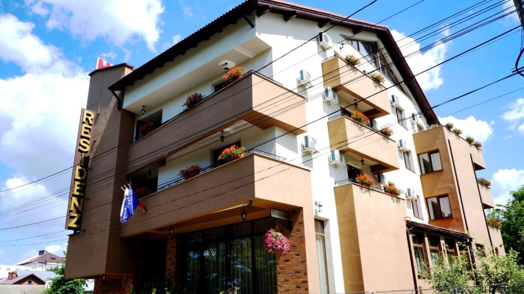 un bâtiment avec des boîtes de fleurs sur son côté dans l'établissement Hotel Residenz, à Suceava