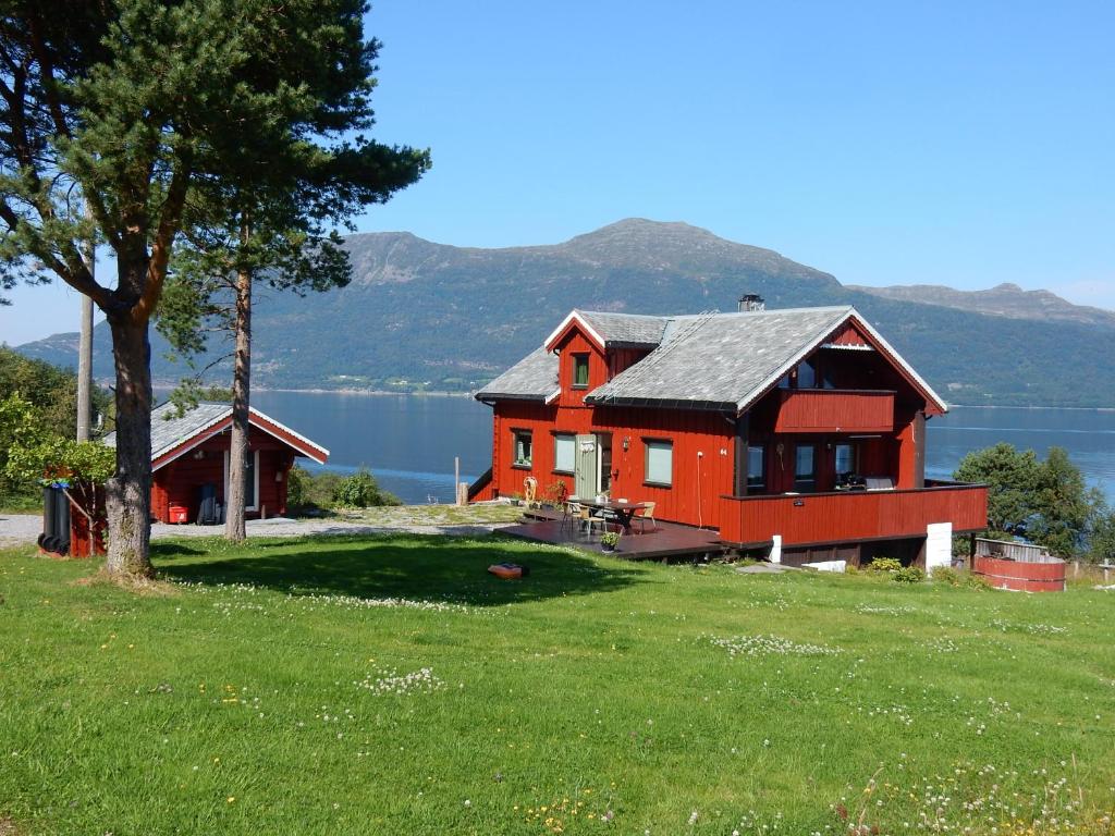 a house on a hill with a lake in the background at Rekdal in Vestnes