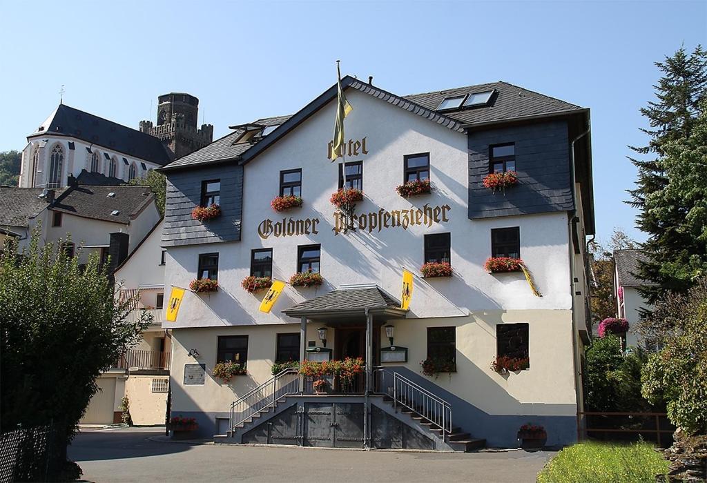 un gran edificio blanco con flores en la parte delantera en Goldener Pfropfenzieher, en Oberwesel