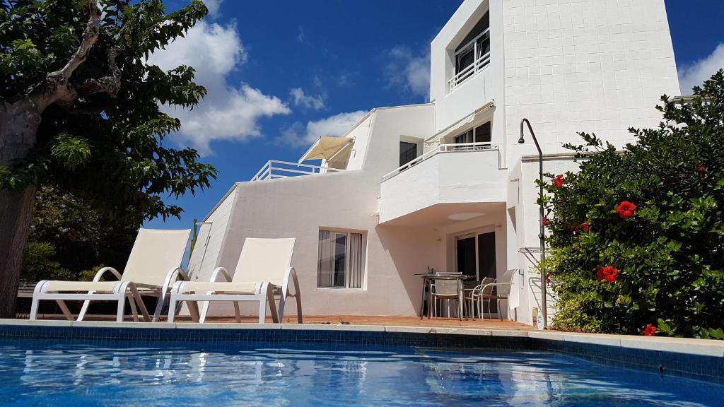 a villa with a swimming pool in front of a house at STARBAL Love in Es Castell