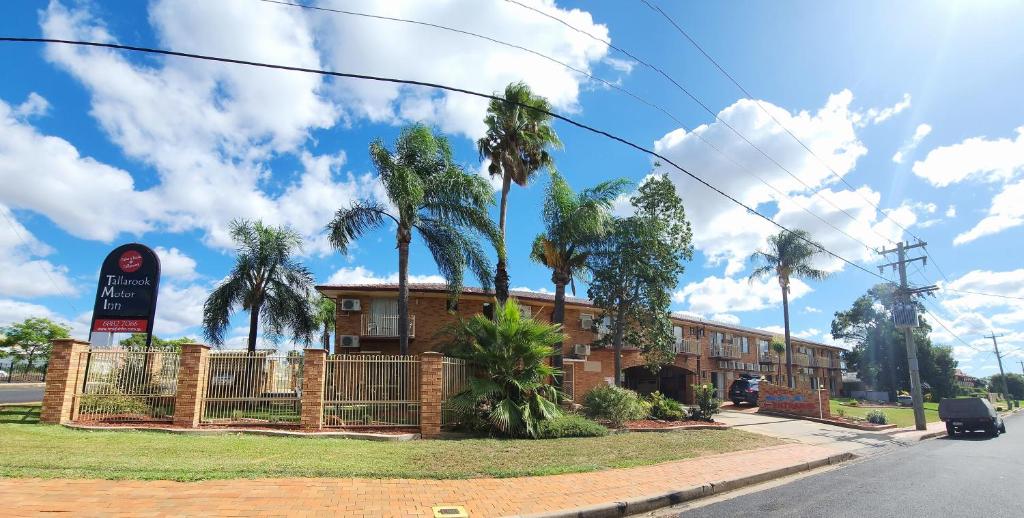 a building with palm trees in front of it at Tallarook Motor Inn in Dubbo