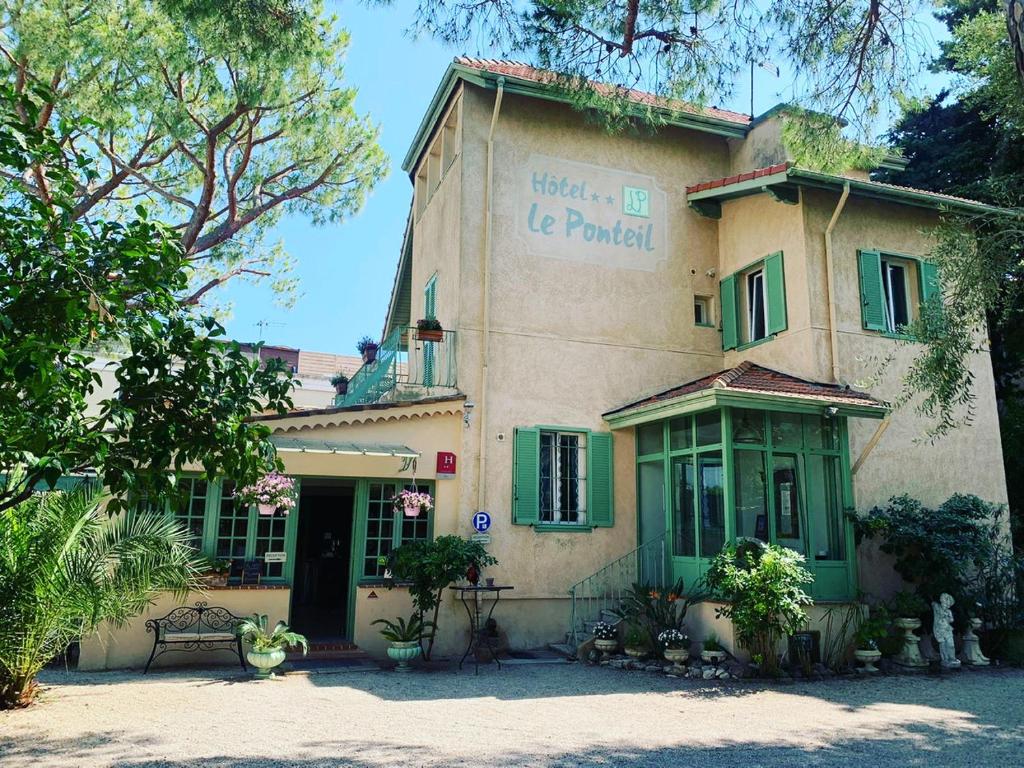 a building with a sign on the side of it at Hotel Le Ponteil in Antibes