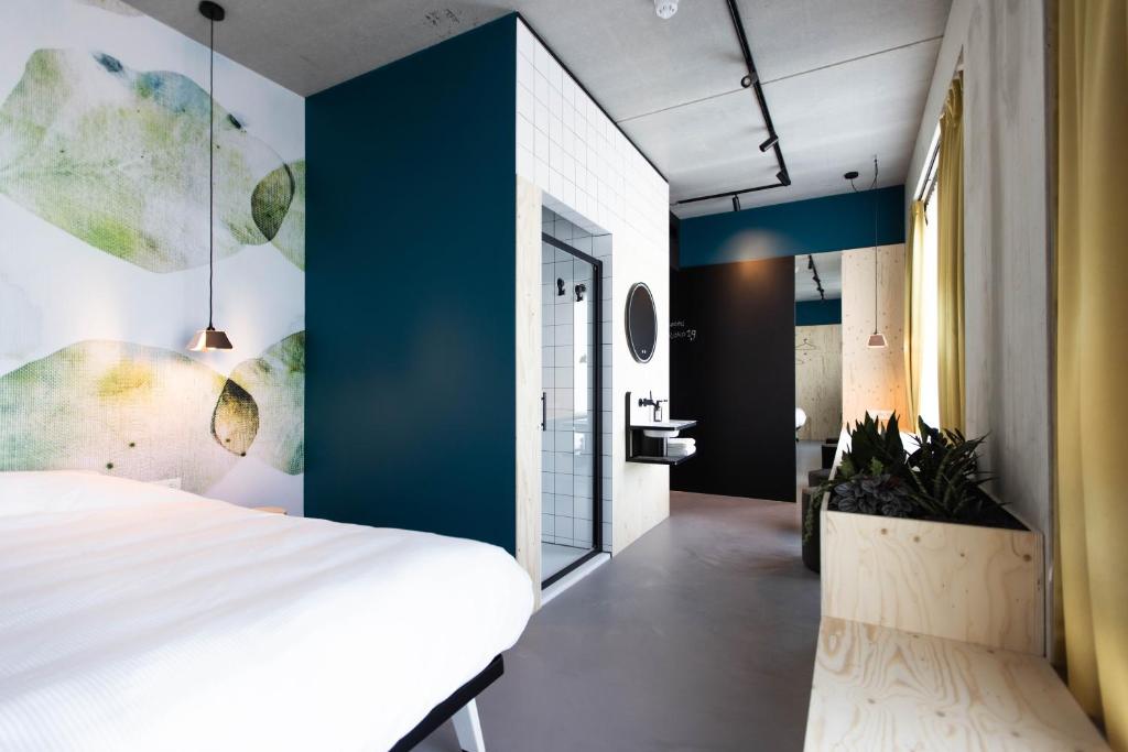 una camera con un letto bianco e una parete blu di hotel Moloko -just a room- sleep&shower-digital key by SMS a Enschede