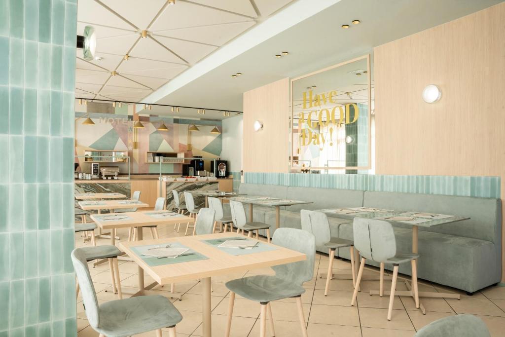 a restaurant with tables and chairs and a counter at Unique Hotel in Cesenatico