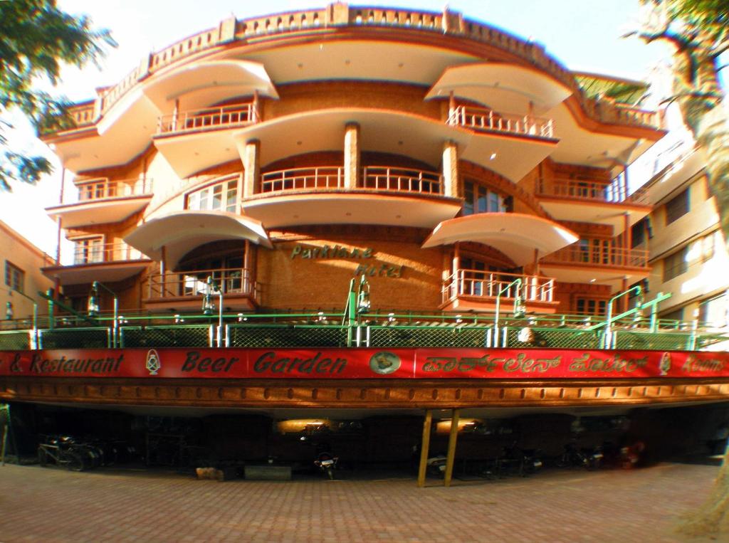 ein großes Gebäude mit einem roten Schild davor in der Unterkunft Parklane Hotel in Mysore