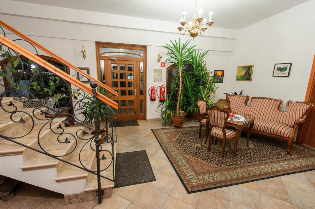 una sala de estar con una escalera y algunas plantas en Hotel Sporn en Radomlje
