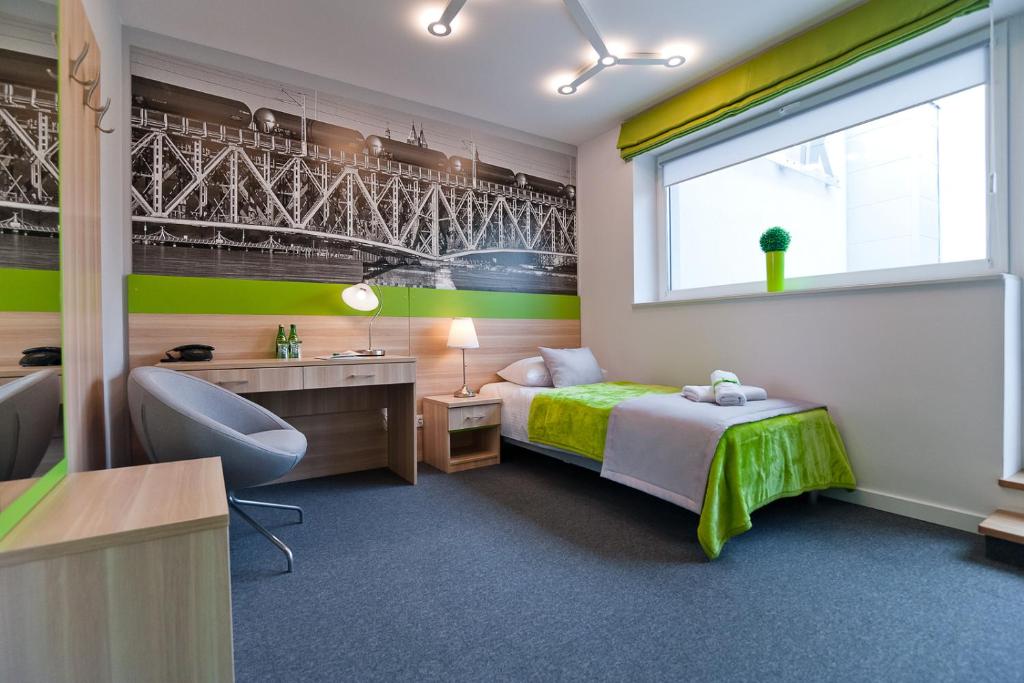 1 dormitorio con cama, escritorio y ventana en Green Hotel Płock en Płock