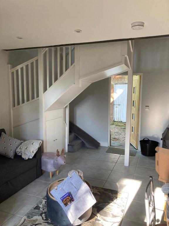 a living room with a staircase and a couch at Raglans in Swindon