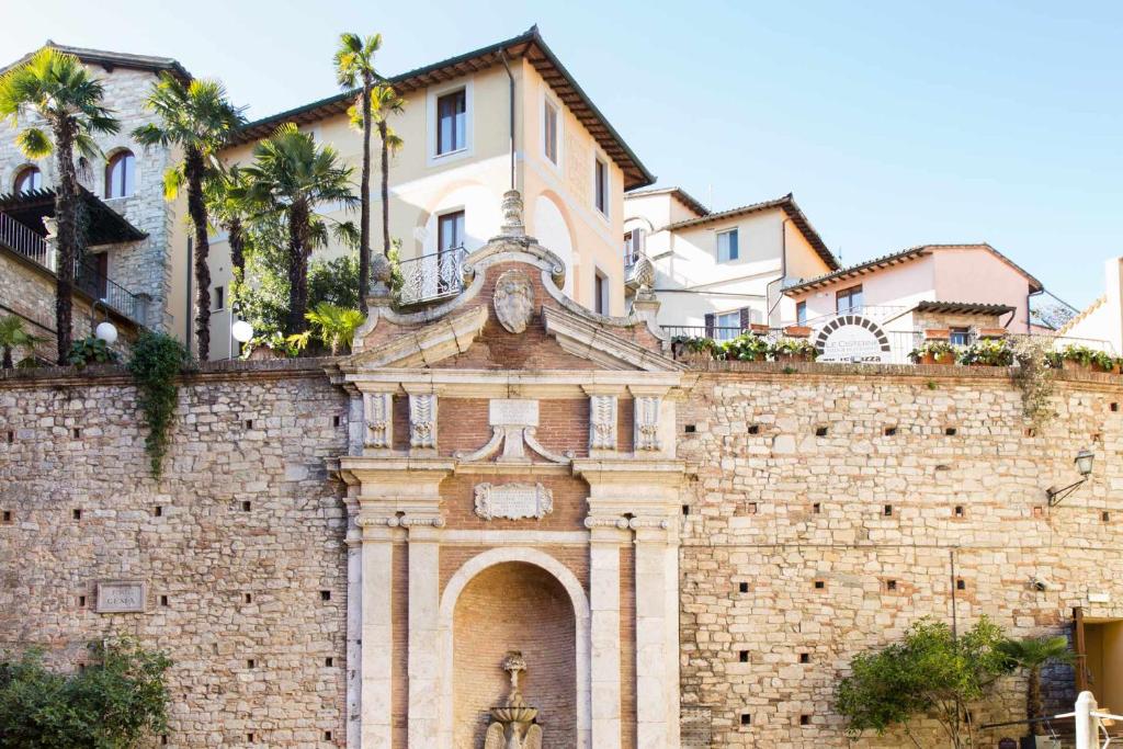 a building with a statue on top of a brick wall at Hotel Fonte Cesia in Todi