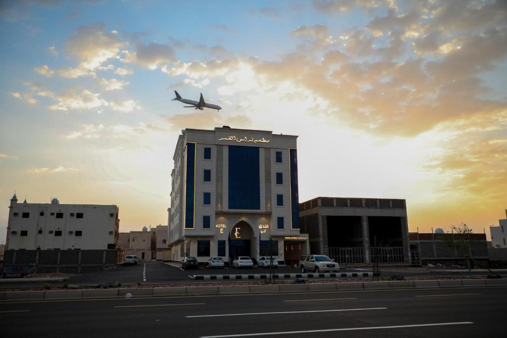 um avião está a sobrevoar um edifício com um edifício em E Hotel em Medina