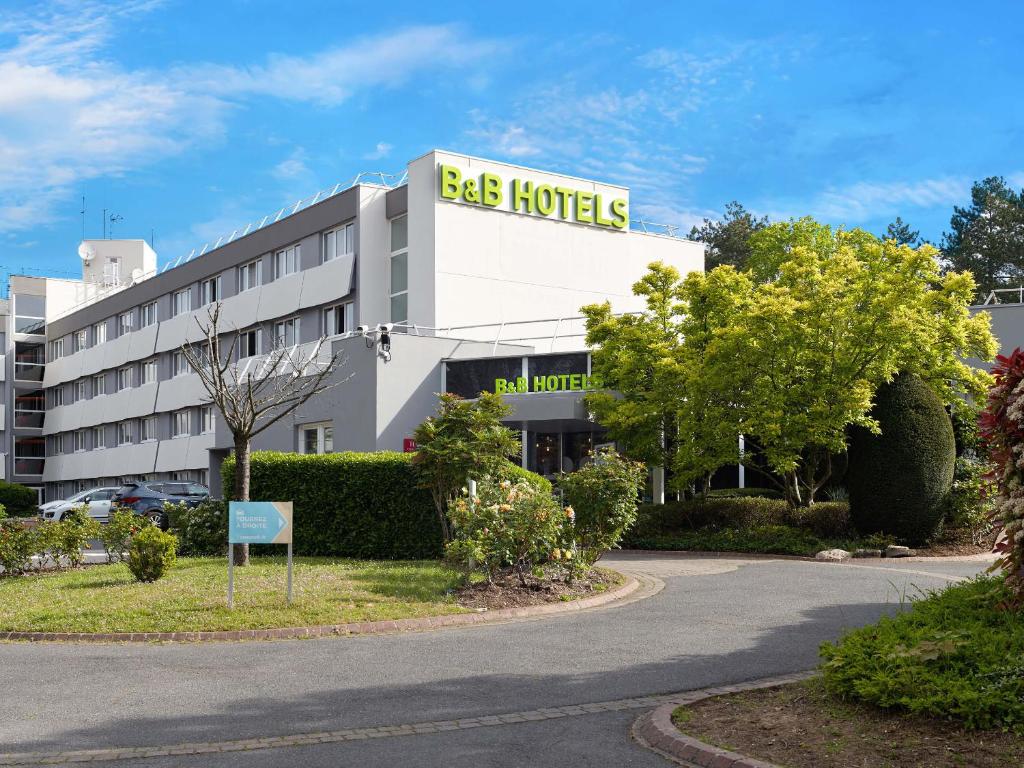 ein Gebäude mit einem Schild, das Bienen-Hotel liest in der Unterkunft B&B HOTEL Cergy Port 4 étoiles in Cergy