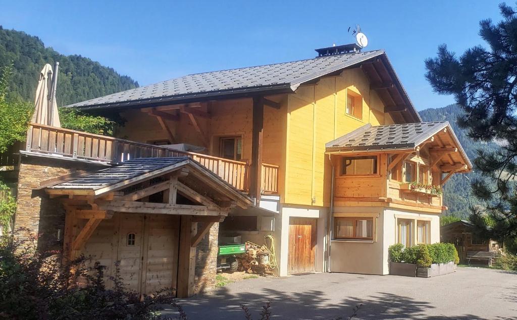 een groot houten huis met een balkon erop bij Chambres d’Hôtes les Hermines in Saint-Nicolas-la-Chapelle