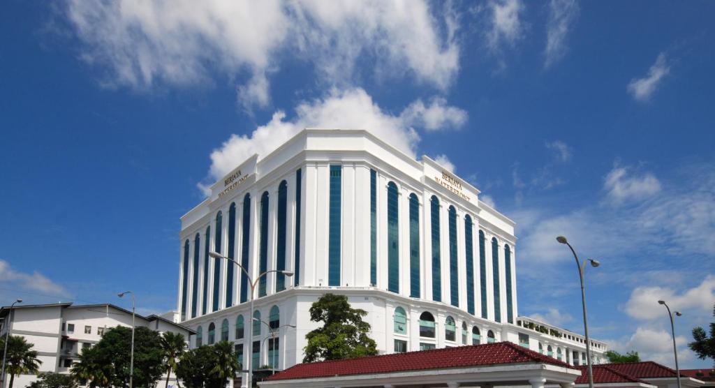 een groot wit gebouw met een blauwe lucht en wolken bij Berjaya Waterfront Hotel, Johor Bahru in Johor Bahru