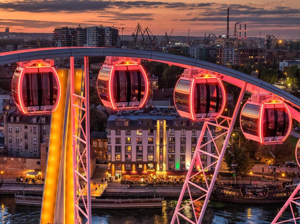 eine Brücke über einen Fluss mit einer Stadt in der Nacht in der Unterkunft Chrobry Apartamenty Gdańsk Grodzka 10 in Danzig