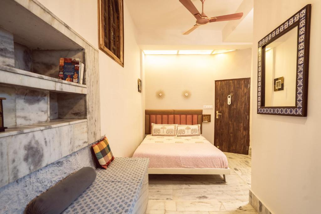 una camera con letto e specchio di Le Fort Homestay a Jaipur