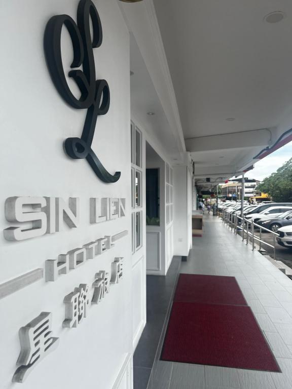 a sign on the side of a building with cars parked at SiN LiEN HOTEL in Kluang