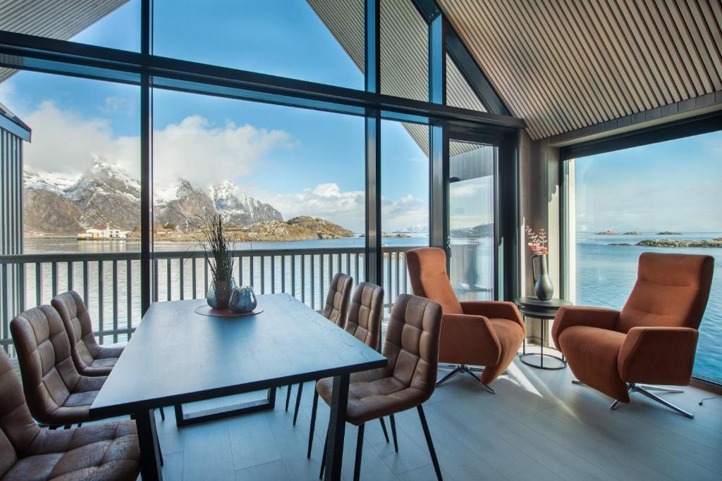 een eetkamer met een tafel en stoelen en bergen bij CornerView Apartment Henningsvær in Henningsvær