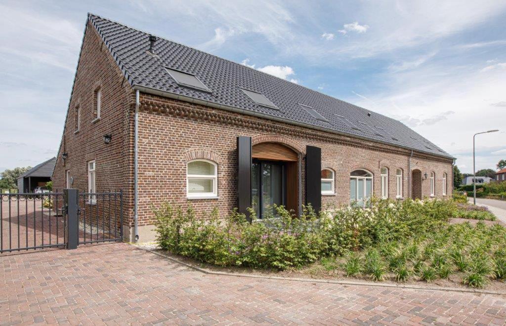 une maison en briques avec un toit solaire dans l'établissement Barn24 - The Stable & The Loft, à Roggel