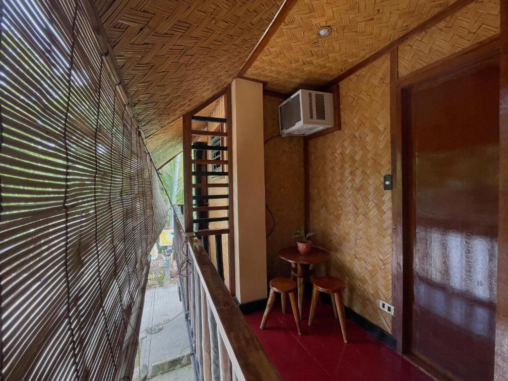 Cette chambre dispose d'un balcon avec une table et un tabouret. dans l'établissement Hidden of Cailan Extension Transient House, à El Nido