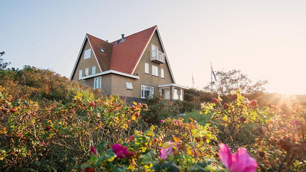 une maison au sommet d'une colline avec des fleurs dans l'établissement Villa Parnassia, à Bergen aan Zee