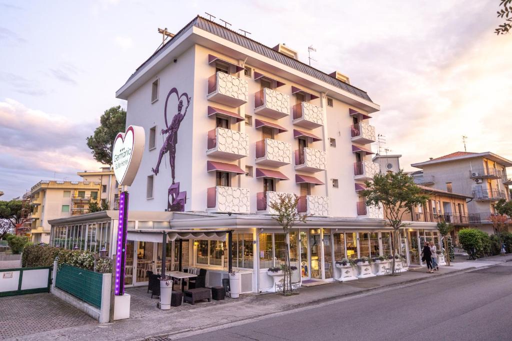 een groot wit gebouw met een bord ervoor bij Hotel Germania in Lido di Jesolo