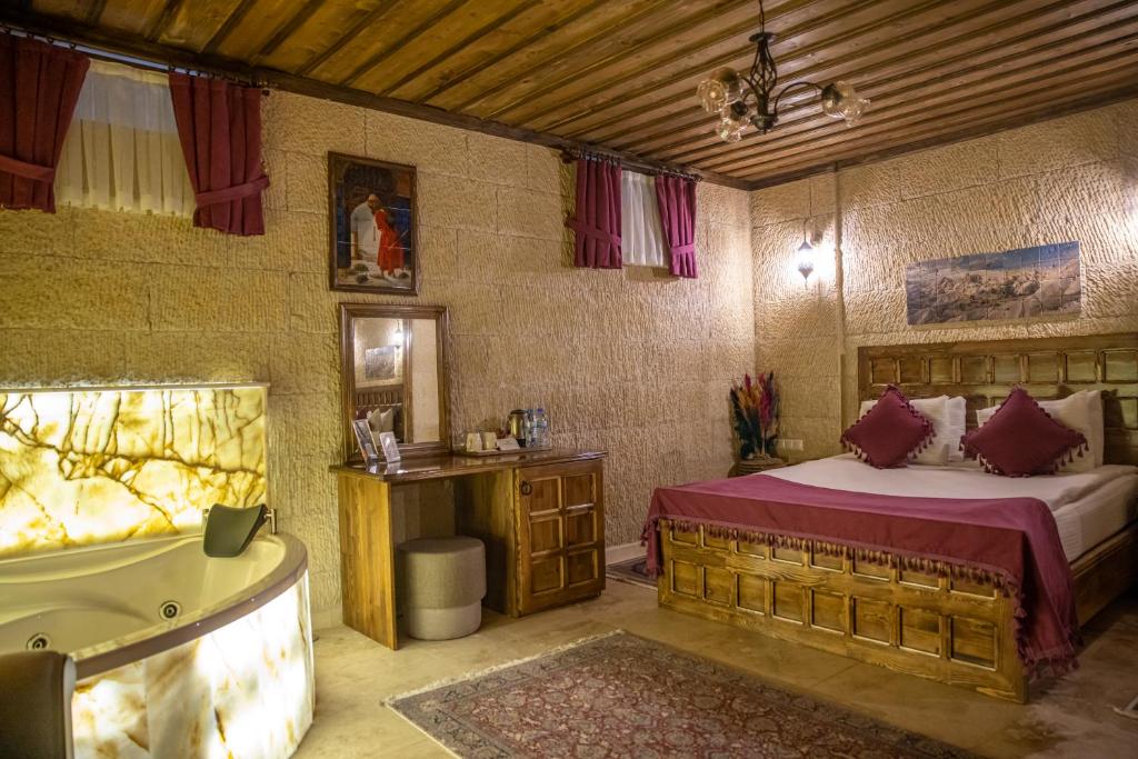 1 dormitorio con 1 cama y bañera en una habitación en Garden Suites Hotel Cappadocia en Goreme