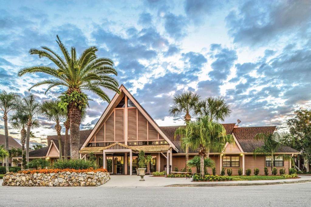 une maison avec des palmiers devant elle dans l'établissement Hilton Vacation Club Polynesian Isles Kissimmee, à Kissimmee