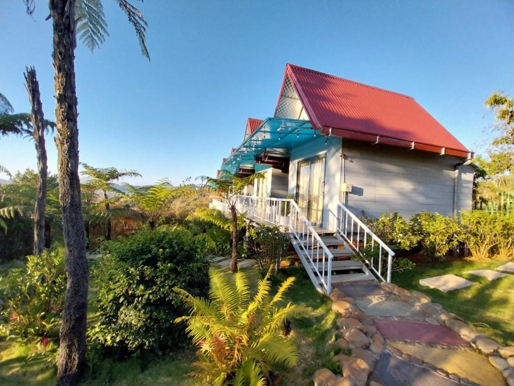 een klein huis met een rood dak en een veranda bij K'Ho Cil Homestay Tà Nung in Da Lat