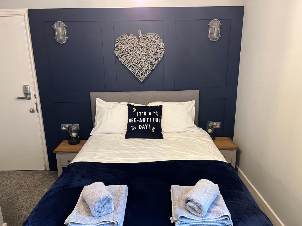 a bedroom with a bed with a heart pillow and towels at Beach Suites in Southport