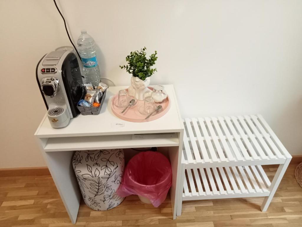 a small white table with a sewing machine and a sink at Fenix Rooms in Trieste