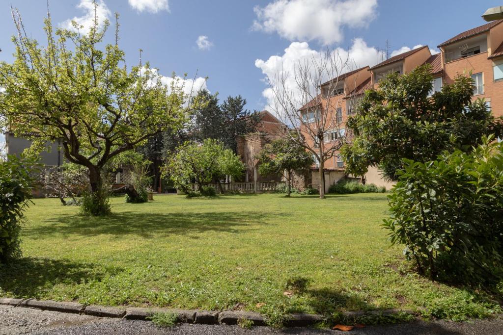 a grassy yard with trees and buildings at Hotel Santa Maura in Rome