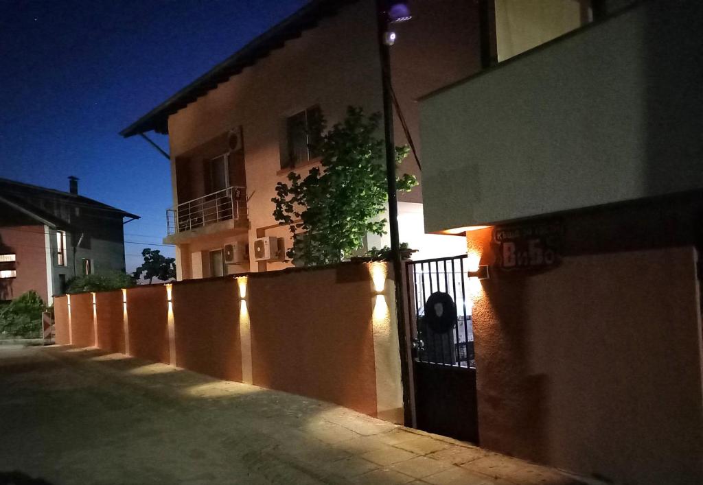 a building with a fence in front of a street at ViBo Guesthouse in Sapareva Banya