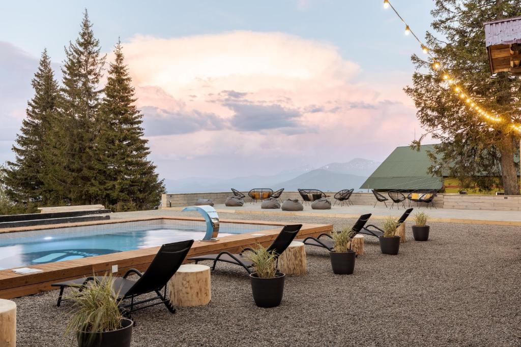 ein Resortpool mit Stühlen und Bergblick in der Unterkunft Gremi Hotel in Drahobrat