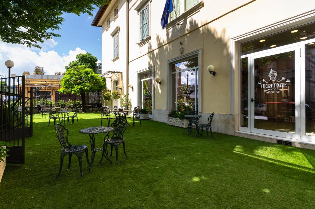 patio z krzesłami i stołami przed budynkiem w obiekcie Hotel Heritage w mieście Fiuggi