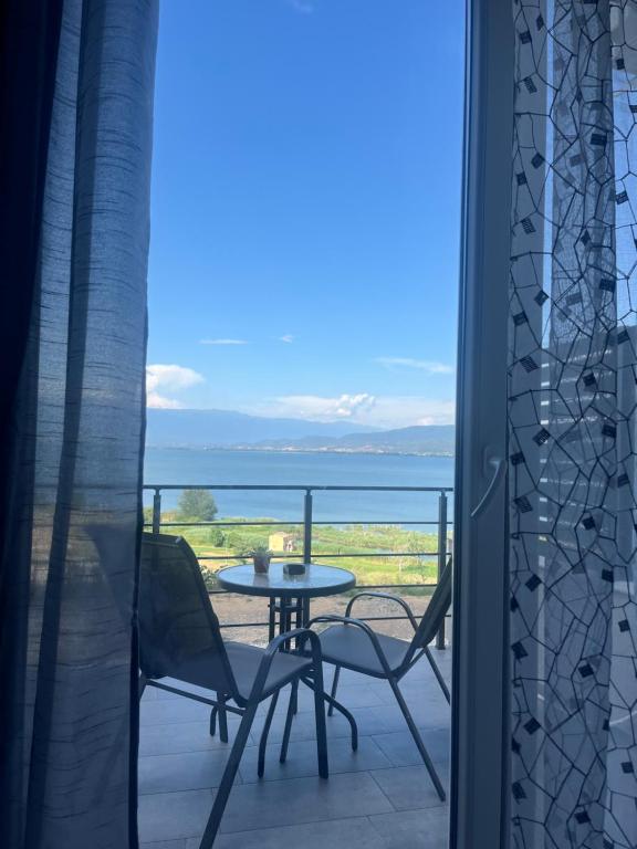 un tavolo e sedie su un balcone con vista sull'oceano di Studio MERAKI a Star Dojran