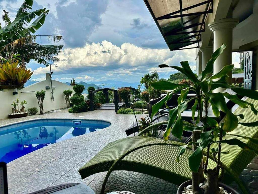 Avana Hills Tagaytay Villa في تاجيتاي: منتجع فيه مسبح وبعض النباتات