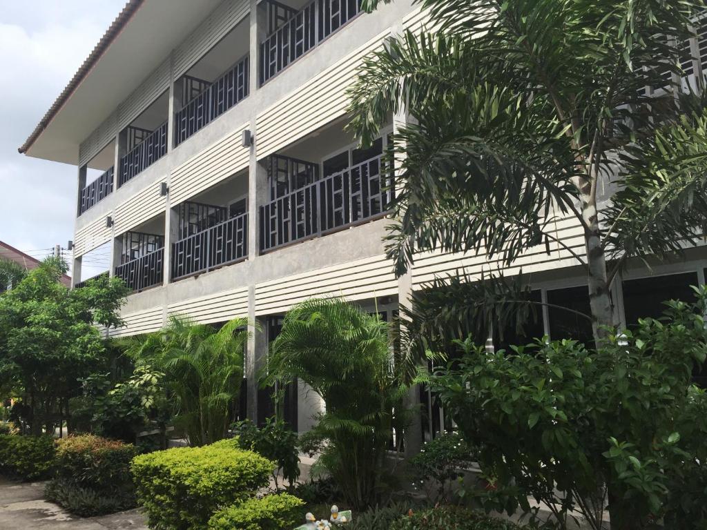 un edificio bianco con alberi di fronte di Baan Suan Ta Hotel a Ko Tao