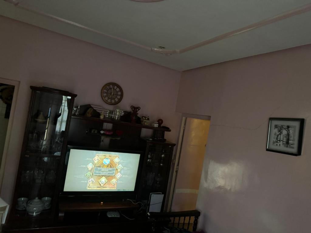 a living room with a flat screen tv in a room at appart charaf in Taza