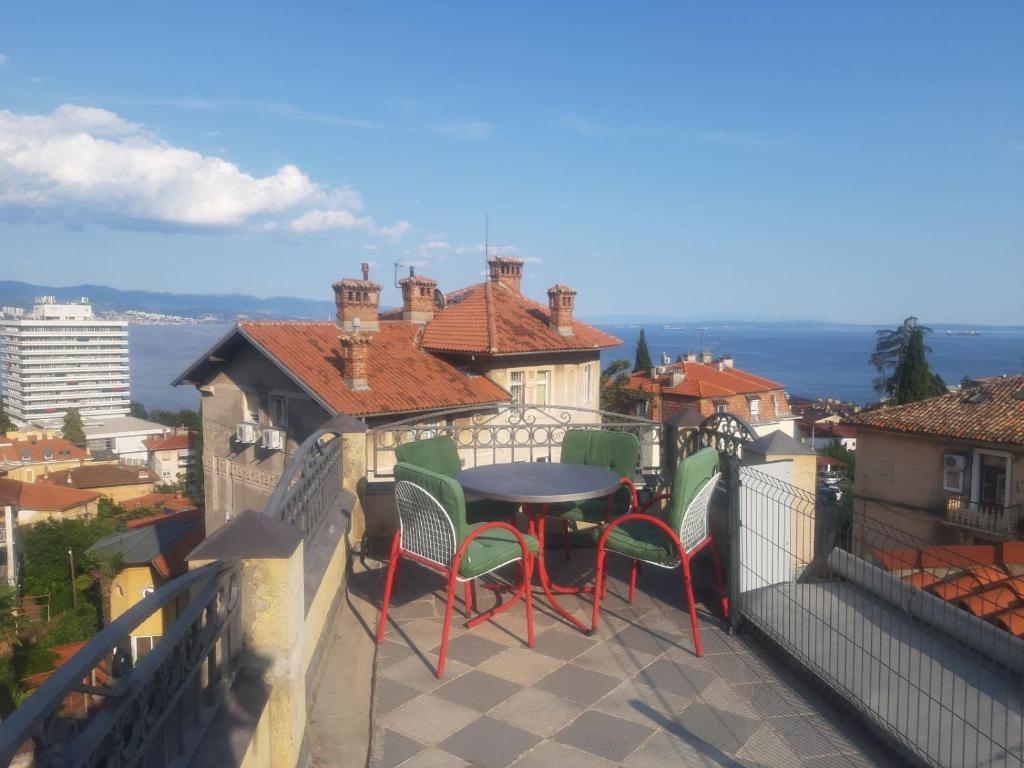 a patio with a table and chairs on a balcony at Apartment Frketić with roof terrace and panoramic sea view in Opatija