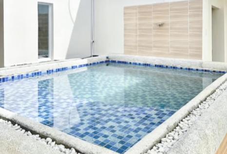 uma piscina com azulejos azuis no chão em Cozy Cove Inn by RedDoorz em Bacolod