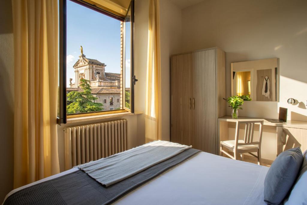 1 dormitorio con vistas a un edificio desde una ventana en Domus Pacis Assisi en Assisi