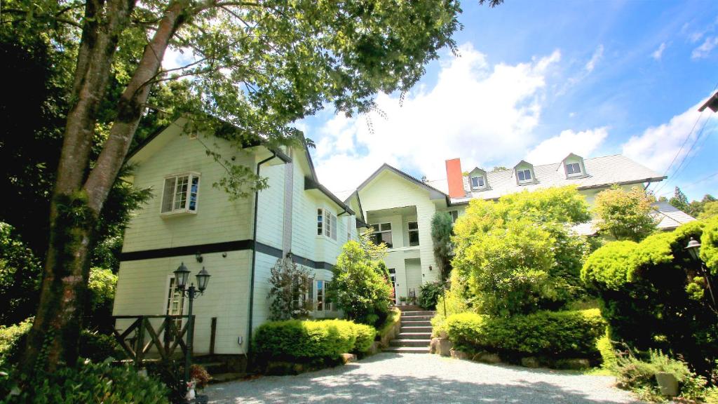 uma grande casa branca com uma escada em frente em Bellbird em Aso