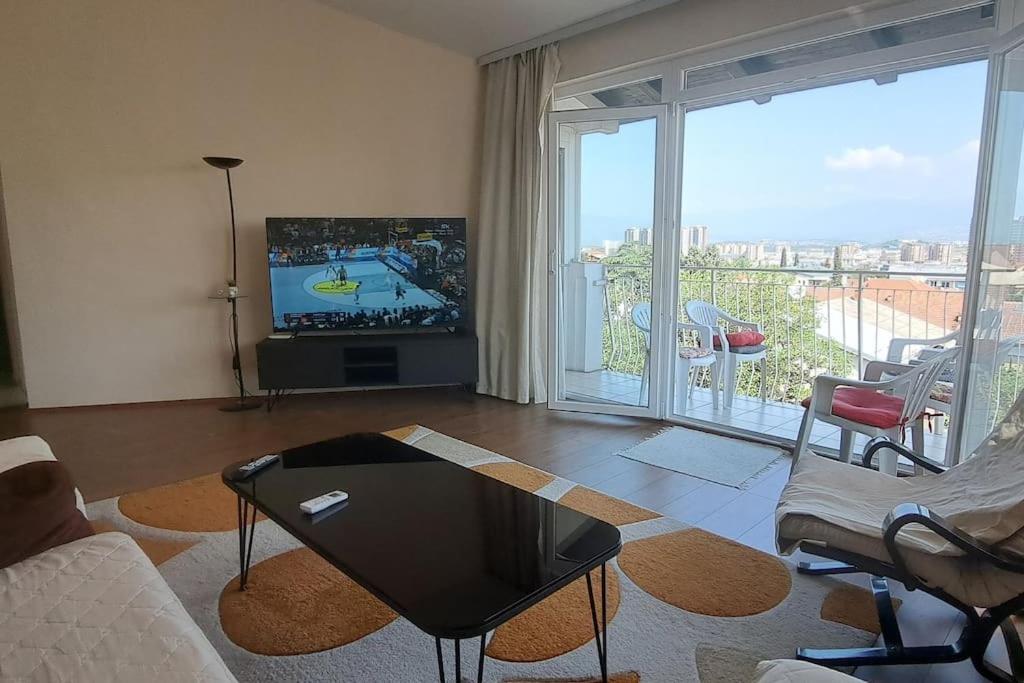 a living room with a tv and a large window at Skopje Panorama in Skopje