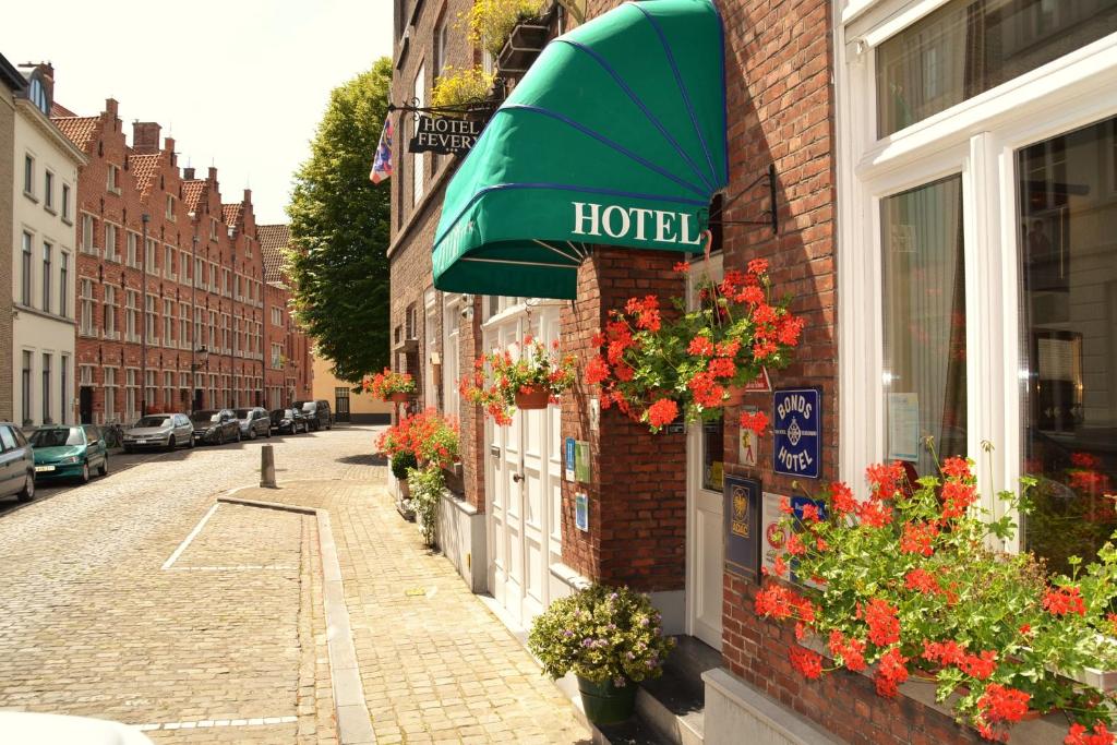 un panneau d'hôtel sur le côté d'un bâtiment en briques dans l'établissement Hotel Fevery, à Bruges